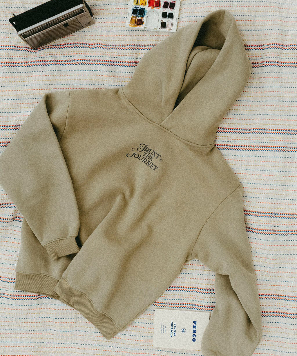 Khaki hoodie with text on a striped fabric background