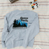 Gray sweatshirt with 'Brave Trails Mountaineering Club' design on a striped blanket background