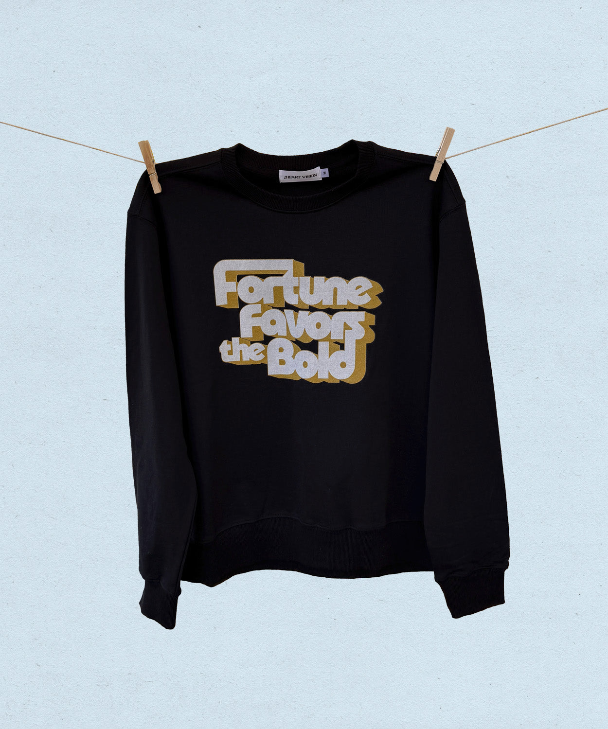 Black sweatshirt with 'Fortune Favors the Bold' text on a light blue background