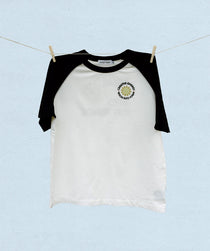 Black and white baseball t-shirt with a logo on a light blue background