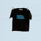 Black t-shirt with blue 'Dare to Dream' text on a clothesline against a light blue background