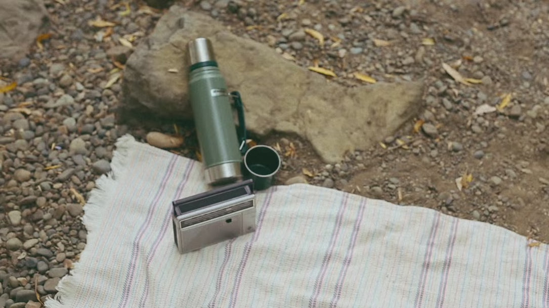 woman walking up to radio and raising the antenna. She is wearing a Heart Vision intentional hoodie with the phrase "the universe has my back" on the back of it.